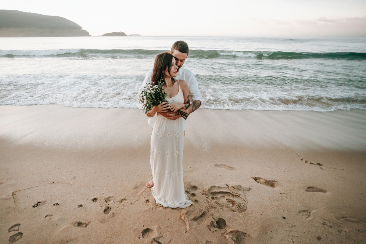 Casal fotografada na Praia do Prumirim em Ubatuba durante ensaio pré-wedding ao pôr do sol com luz natural.