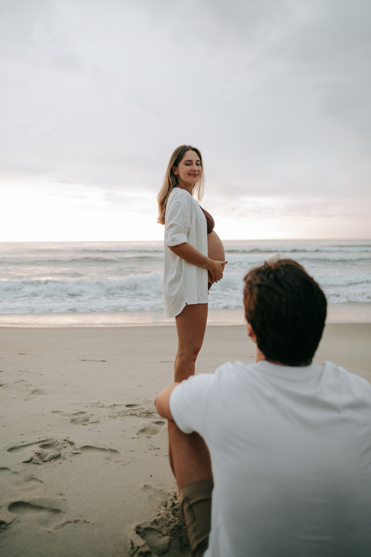Casal aguardando a chegada do bebê durante ensaio gestante na praia de Ubatuba.