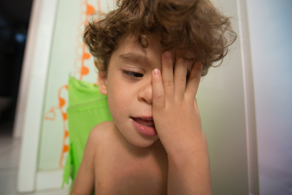 Ícaro fechando um dos olhos com as mãos 