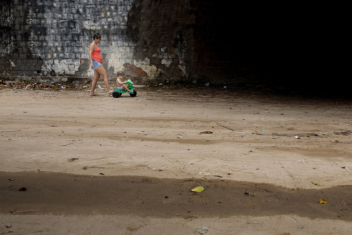 mãe empurrando velocipede com o pé