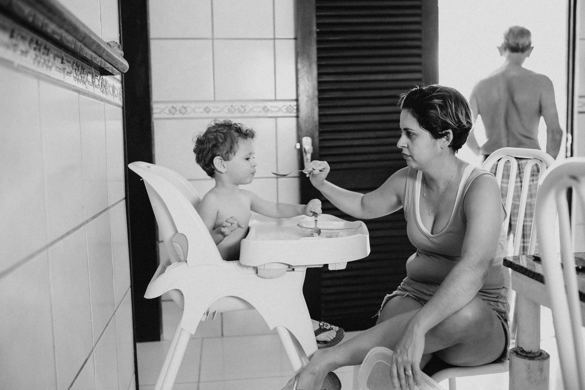 mãe dando o almoço do filho