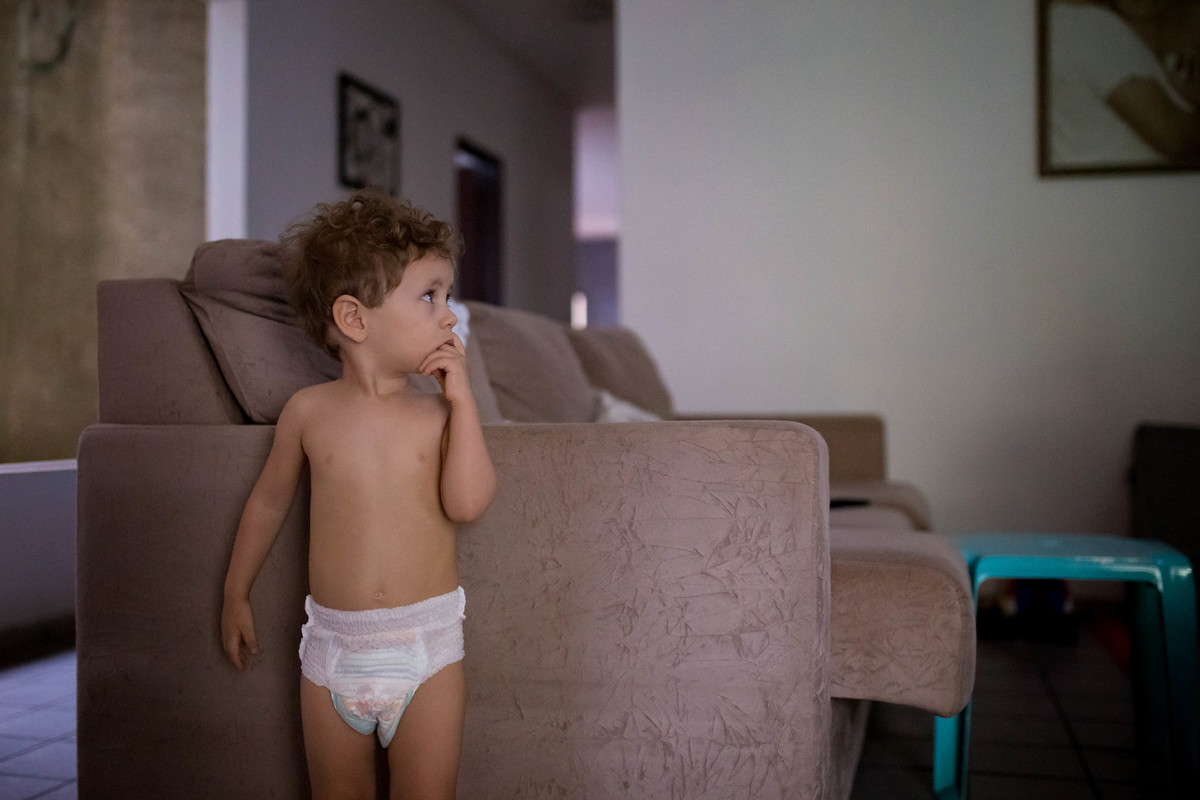 criança olhando para o lado com o dedo na boca