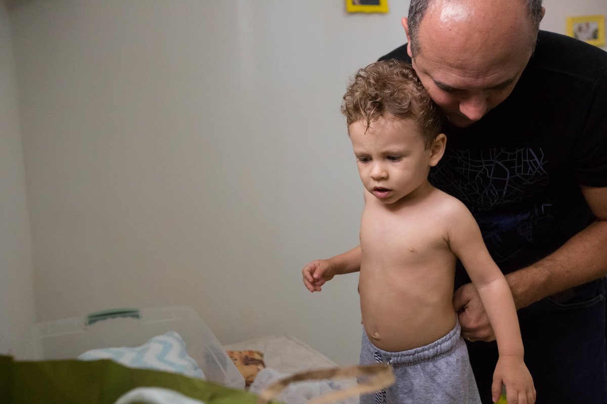 pai vestindo a roupa no filho