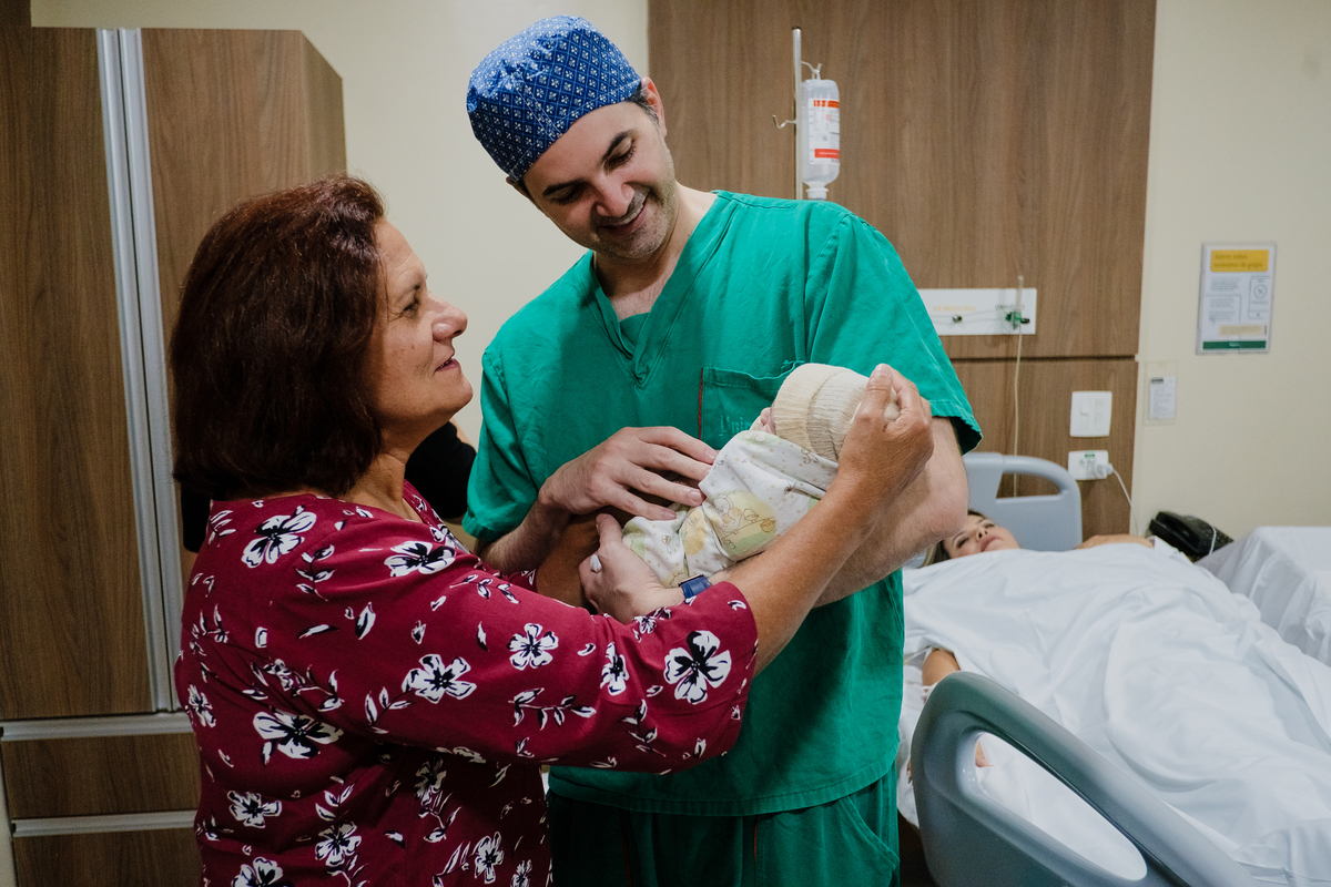 avó e pai segurando bebe
