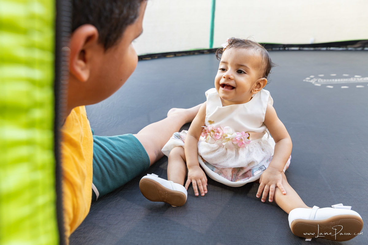 aniversariante olhando para irmão e rindo em aniversario infantil com tema jardim encantado, numa festa de menina em macau, 