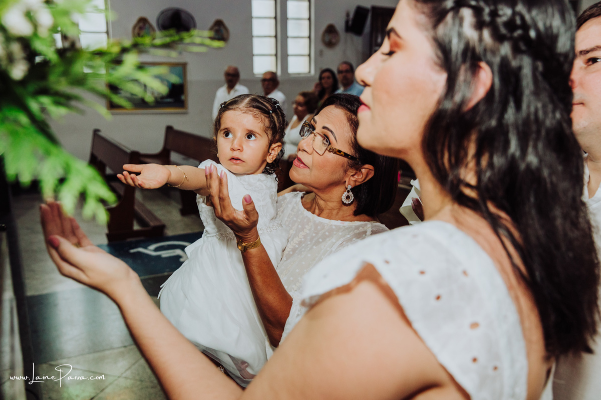 Menina no colo da vó, dos padrinhos e pais que adoram e rezam para nossa senhora em seu batismo e aniversario de dois anos na igreja São João Batista no bairro Lagoa Seca em Natal.