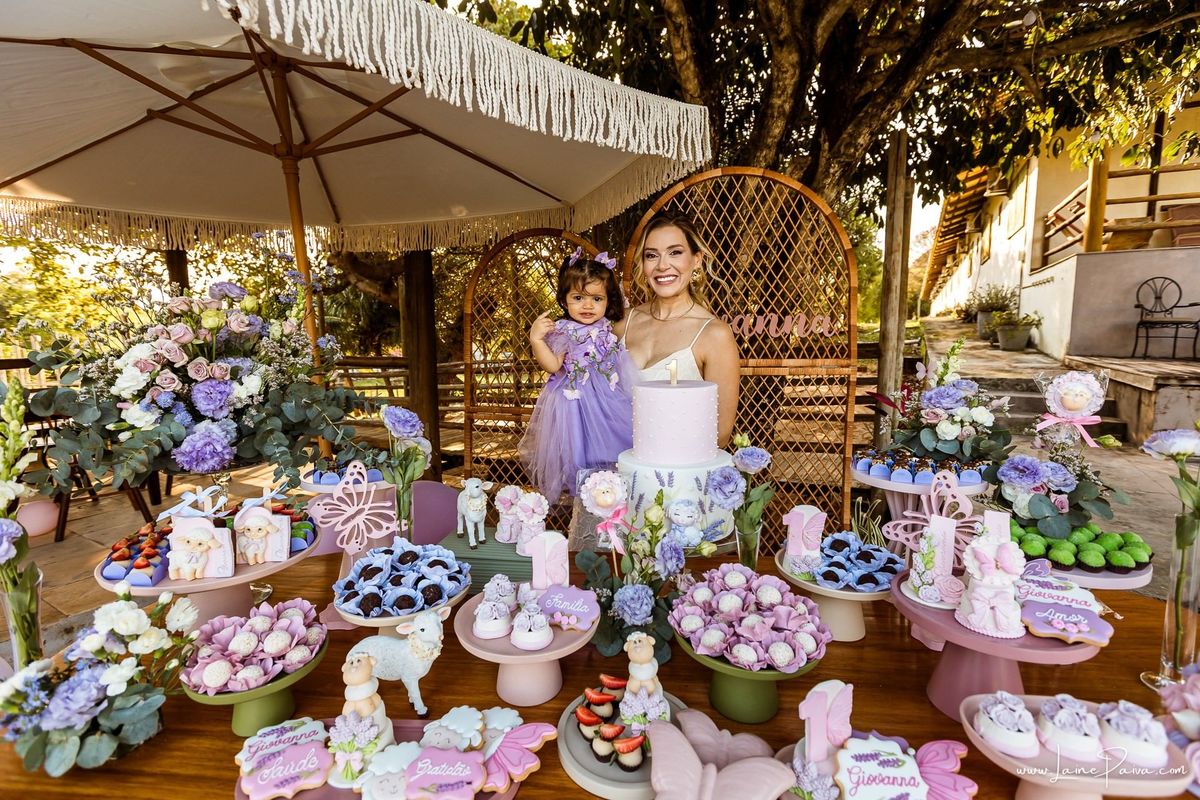 Retrato da Giovana com sua mãe na mesa decorada em sua festa de 1 ano, uma tarde de brincadeiras, afeto e encontros especiais no Complexo Capiba. Fotografia infantil espontânea em Natal, RN.