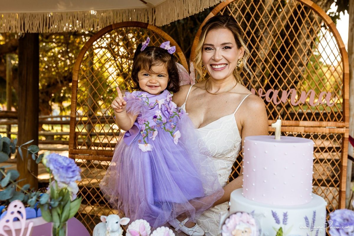 Retrato da Giovana com sua mãe na mesa decorada em sua festa de 1 ano, uma tarde de brincadeiras, afeto e encontros especiais no Complexo Capiba. Fotografia infantil espontânea em Natal, RN.
