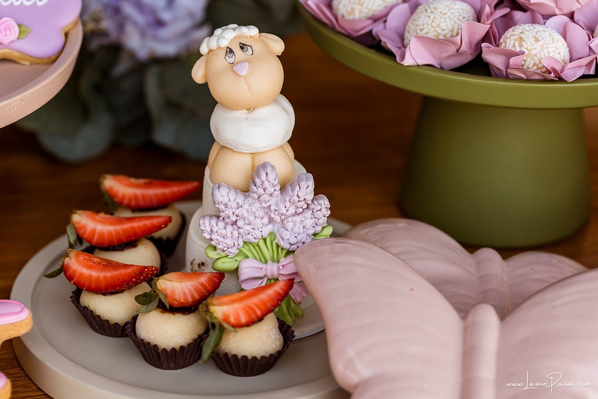 Detalhes da delicada decoração com tema de carneirinhos para a festa de 1 ano da Giovana, preparada com carinho pela família. Fotografia de aniversário infantil em Natal, RN.