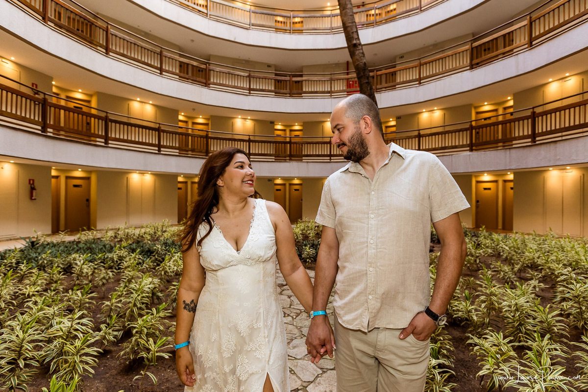 Ensaio romântico de casal em Natal, Rio Grande do Norte, com registros espontâneos feitos no Costeira Palace Resort e a paisagem do Morro do Careca e da árvore dentro do hotel como cenário.