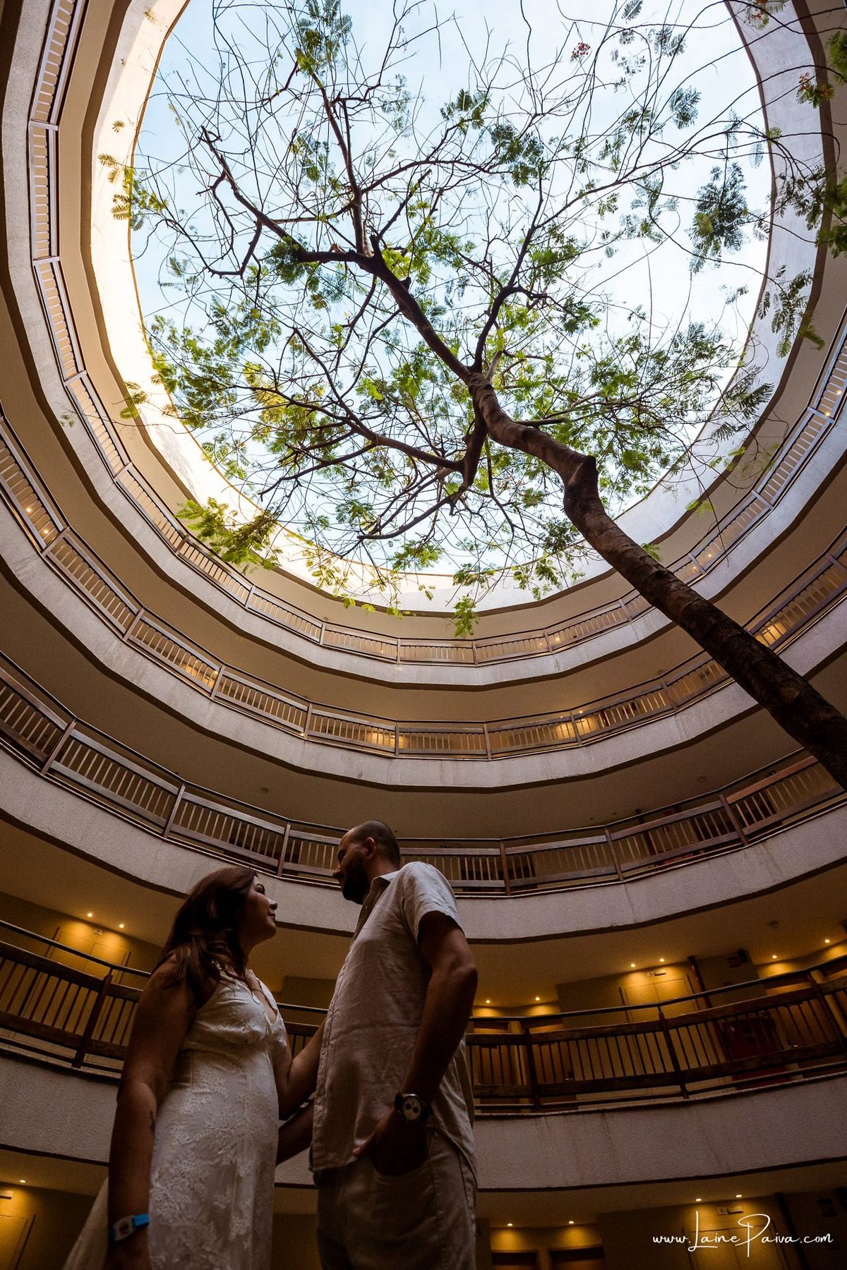 Ensaio romântico de casal em Natal, Rio Grande do Norte, com registros espontâneos feitos no Costeira Palace Resort e a paisagem do Morro do Careca e da árvore dentro do hotel como cenário.