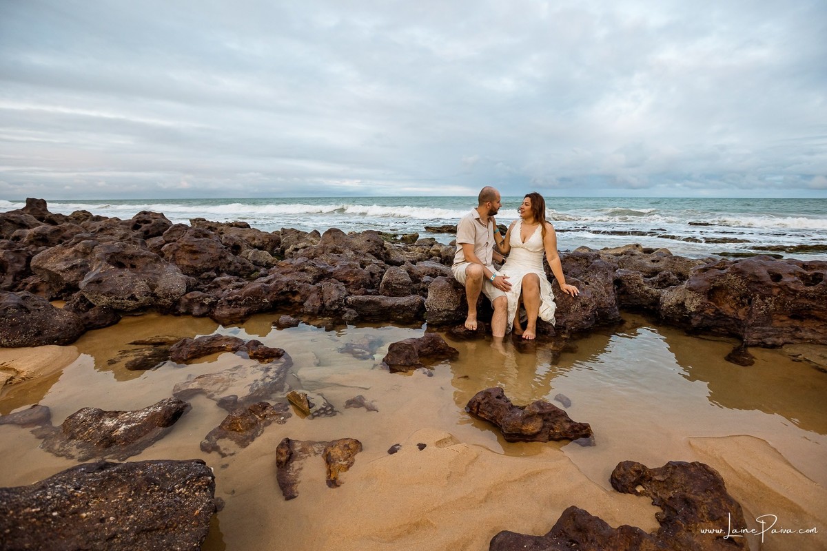 Ensaio fotográfico de casal em Ponta Negra, Natal, registrando abraços, sorrisos e momentos de conexão durante as férias de um casal que veio de Minas Gerais.