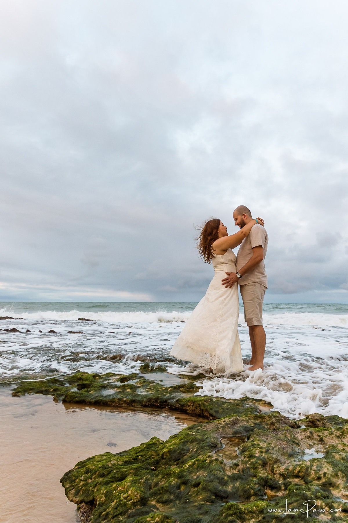 Ensaio fotográfico de casal em Ponta Negra, Natal, registrando abraços, sorrisos e momentos de conexão durante as férias de um casal que veio de Minas Gerais.