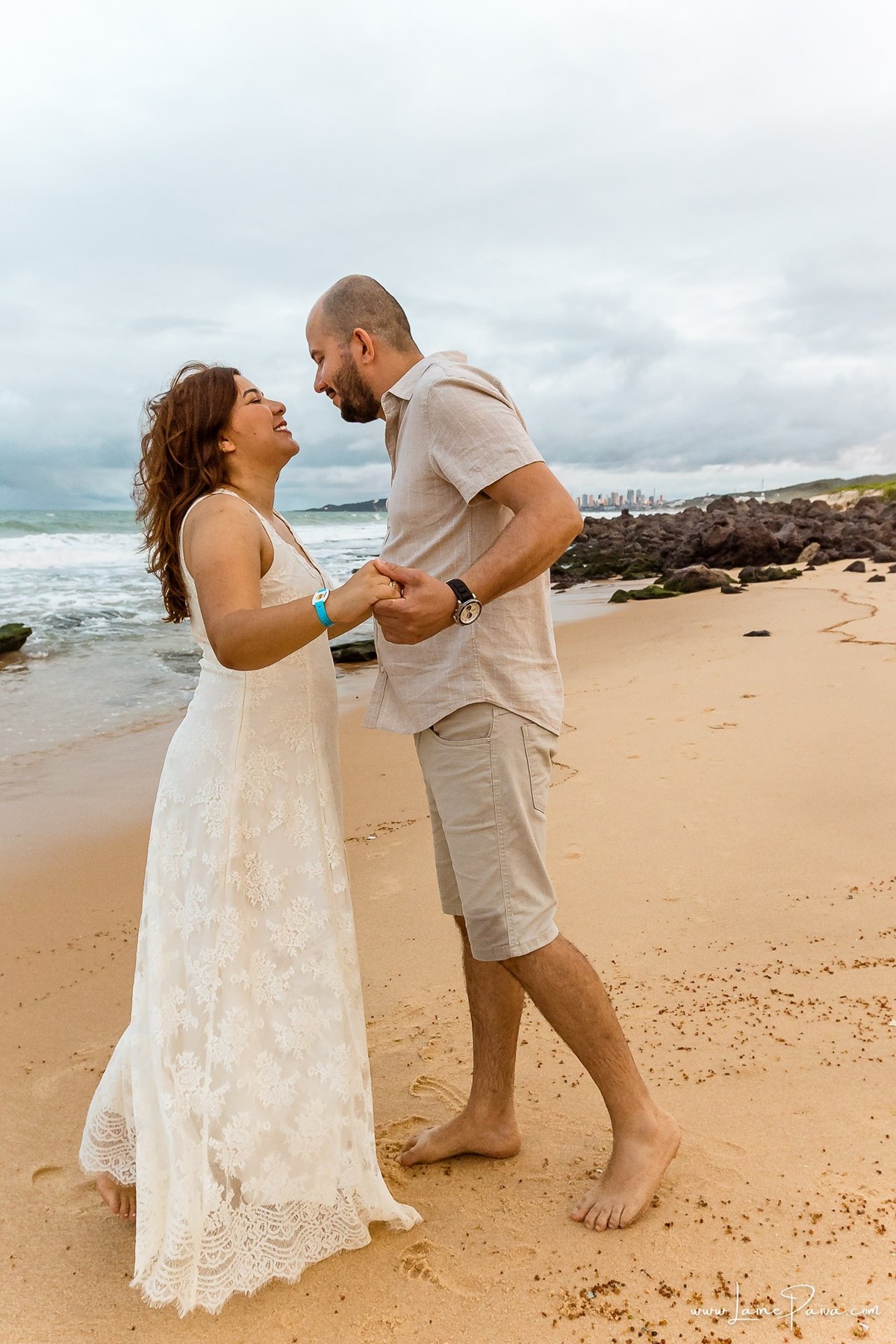 Ensaio fotográfico de casal em Ponta Negra, Natal, registrando abraços, sorrisos e momentos de conexão durante as férias de um casal que veio de Minas Gerais.