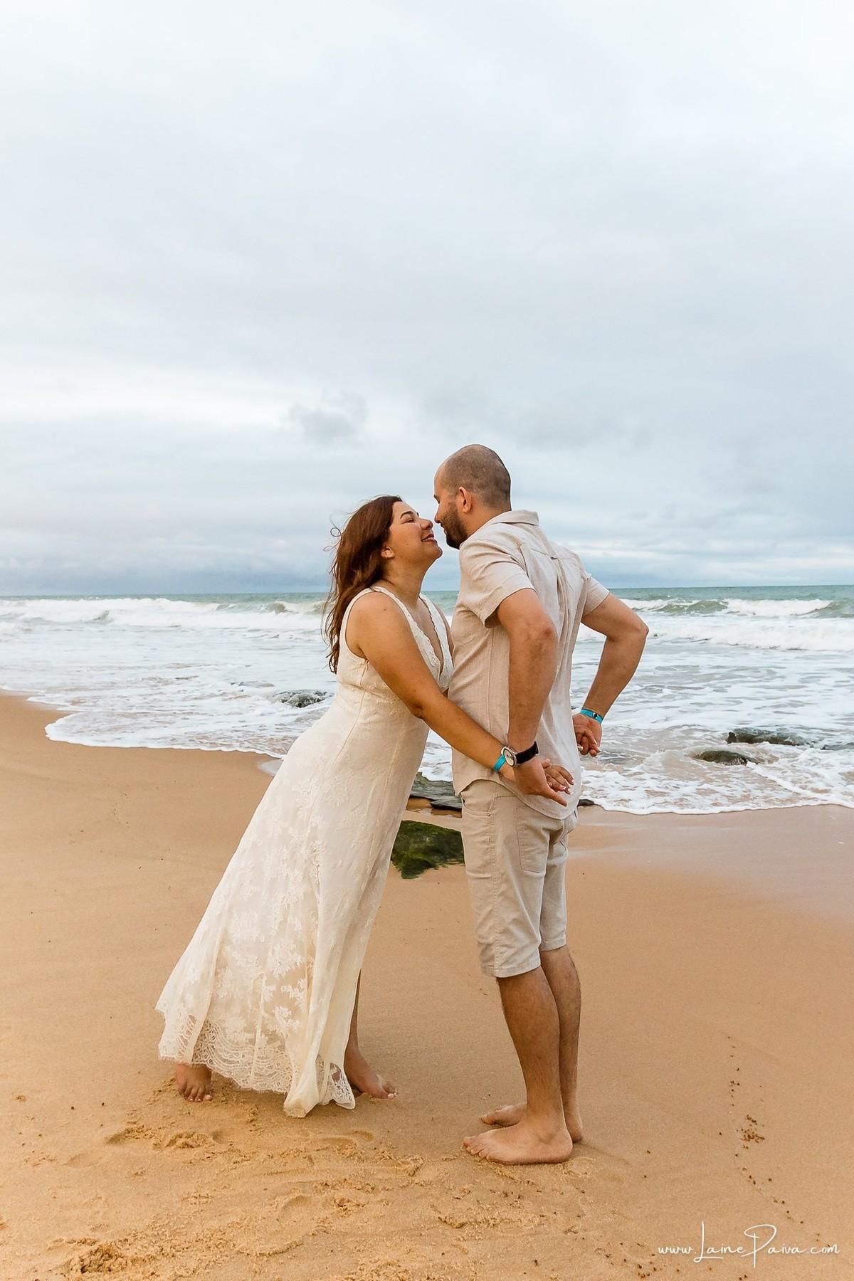 Fotografia de casal em Natal com o Morro do Careca ao fundo. Um ensaio leve, natural e afetivo realizado durante as férias na praia de Ponta Negra.