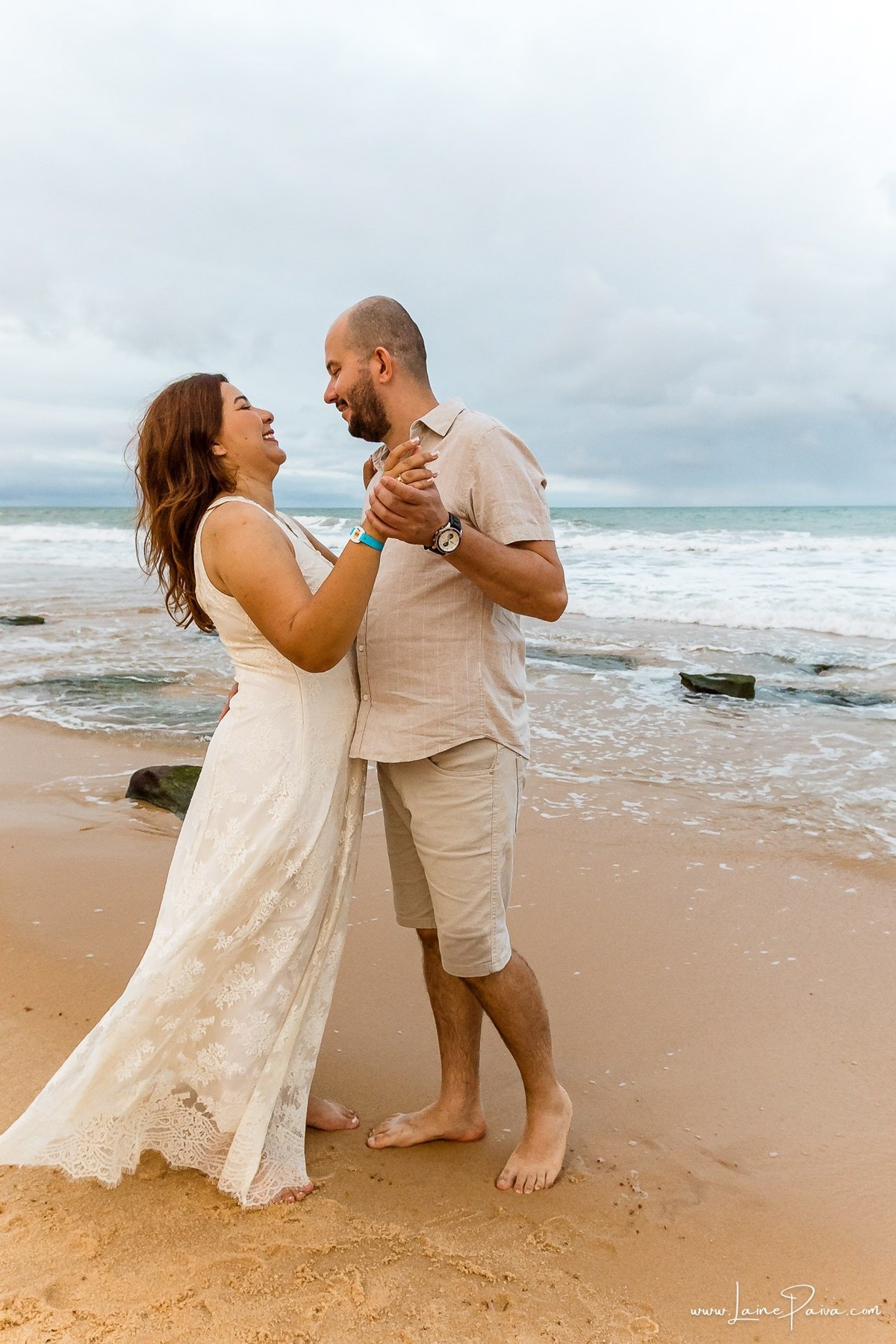 Fotografia de casal em Natal com o Morro do Careca ao fundo. Um ensaio leve, natural e afetivo realizado durante as férias na praia de Ponta Negra.