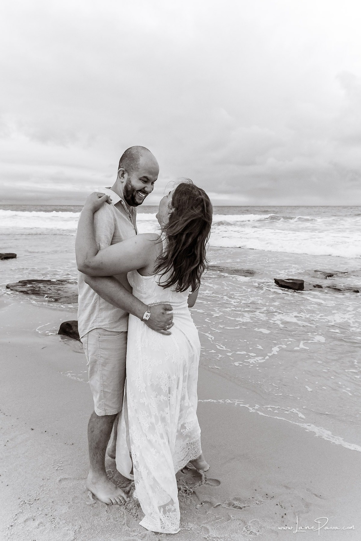 Fotografia de casal em Natal com o Morro do Careca ao fundo. Um ensaio leve, natural e afetivo realizado durante as férias na praia de Ponta Negra.