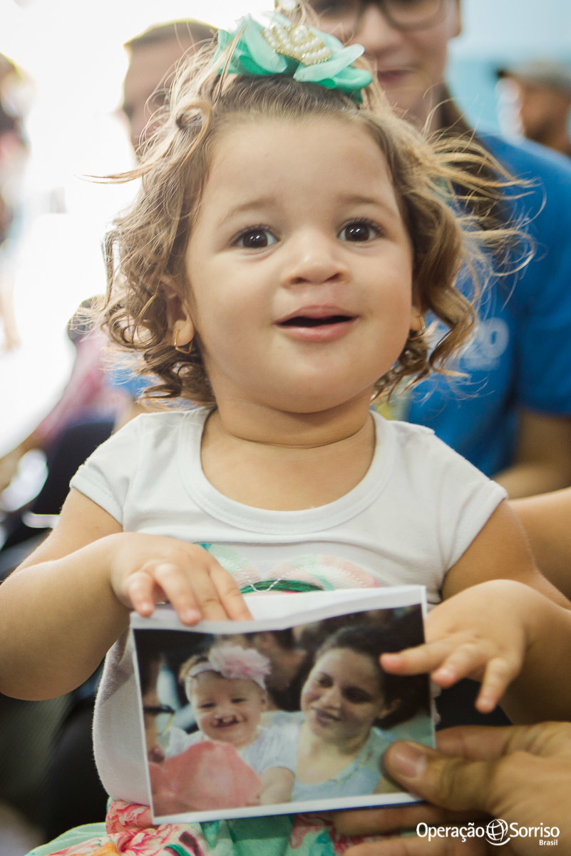 criança segurando sua foto antiga quando era fissurada