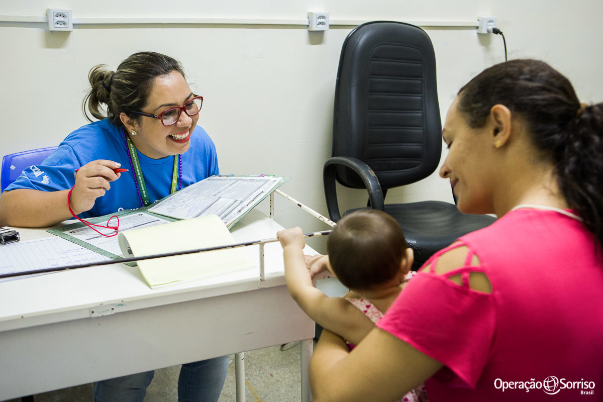 fonoaudióloga brincando com criança na triagem da operação sorriso 