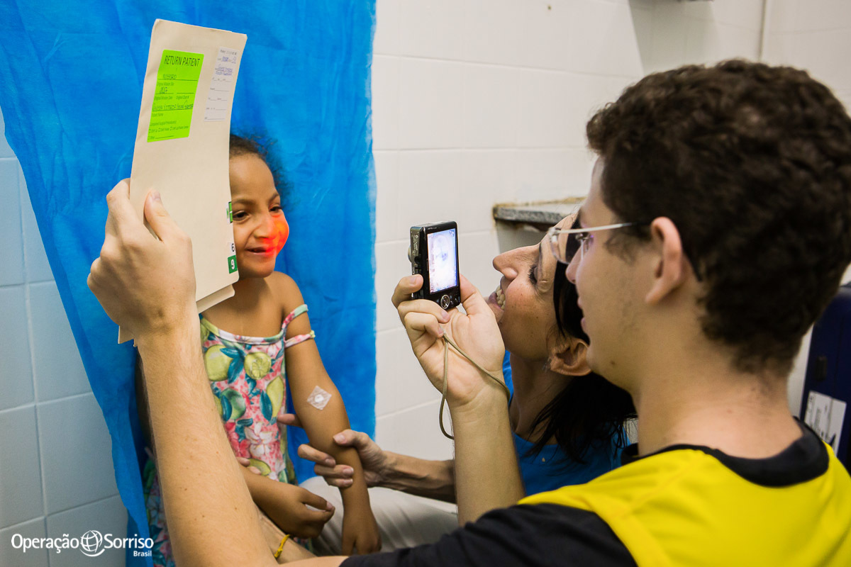 criança fissurada na triagem operação sorriso sendo fazendo fotos tecnicas e sorrindo 