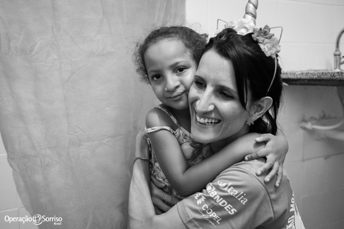 criança fissurada  na triagem operação sorriso abraçando voluntario