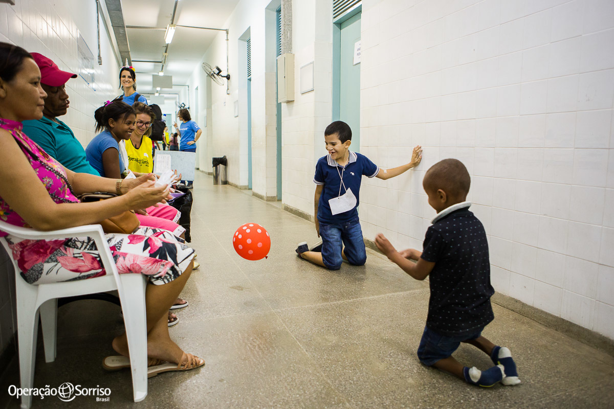 criança fissurada na triagem operação sorriso brincando com bola nos corredores do hospital junto com um amiguinho