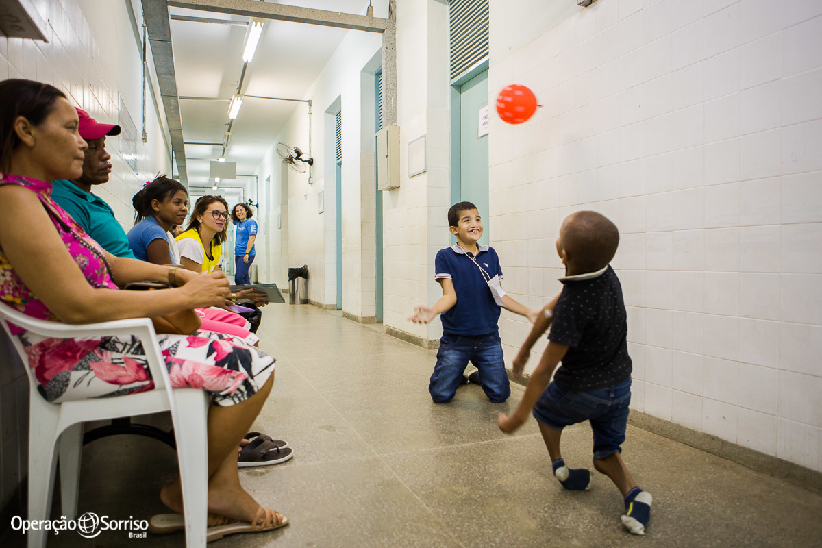 crianças fissuradas na triagem operação sorriso brincando com bola nos corredores do hospital .
