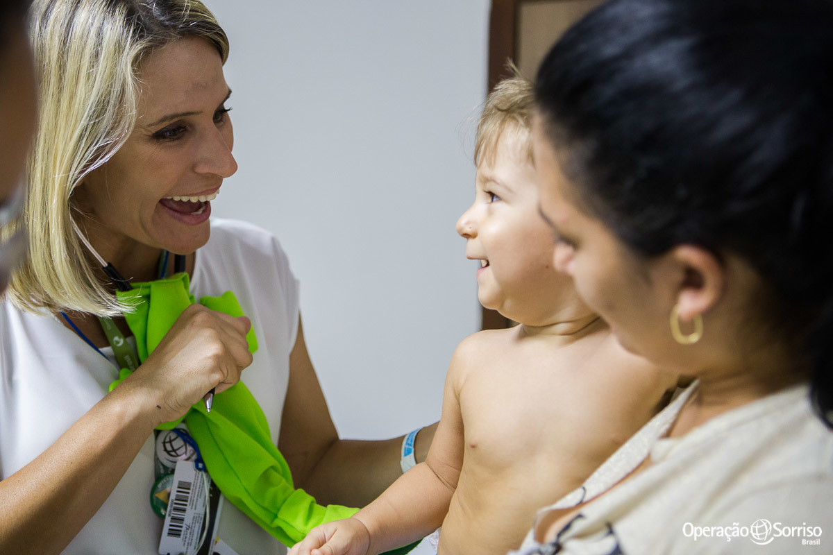 criança sendo atendida pela voluntaria e pediatra da operação sorriso