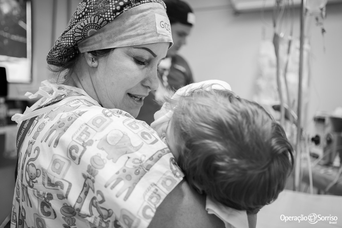 anestesista e voluntaria da Operação Sorriso acalmando criança antes da cirurgia