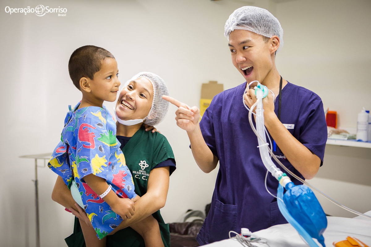 anestesista e voluntario da Operação Sorriso brincando com criança antes da cirurgia