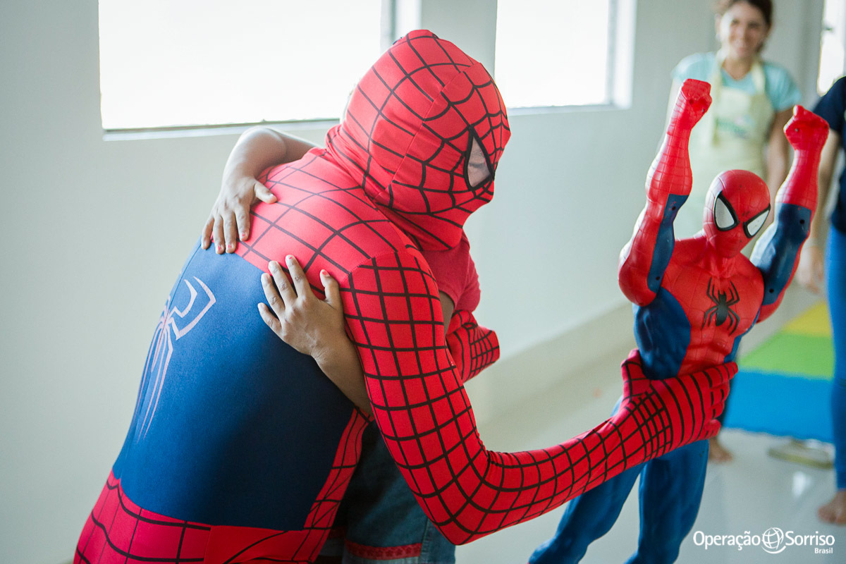 homem aranha abraçando criança no corredor do hospital e segurando boneco
