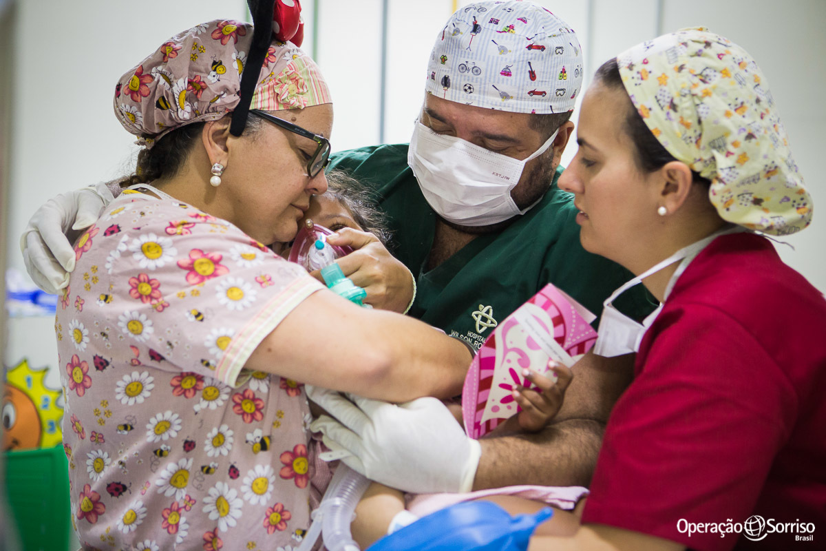 voluntarios abraçando criança