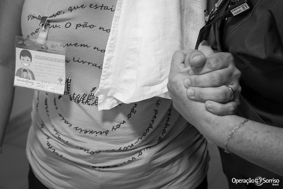 psicologa segurando a mão da mãe da criança que entrou no centro cirurgico