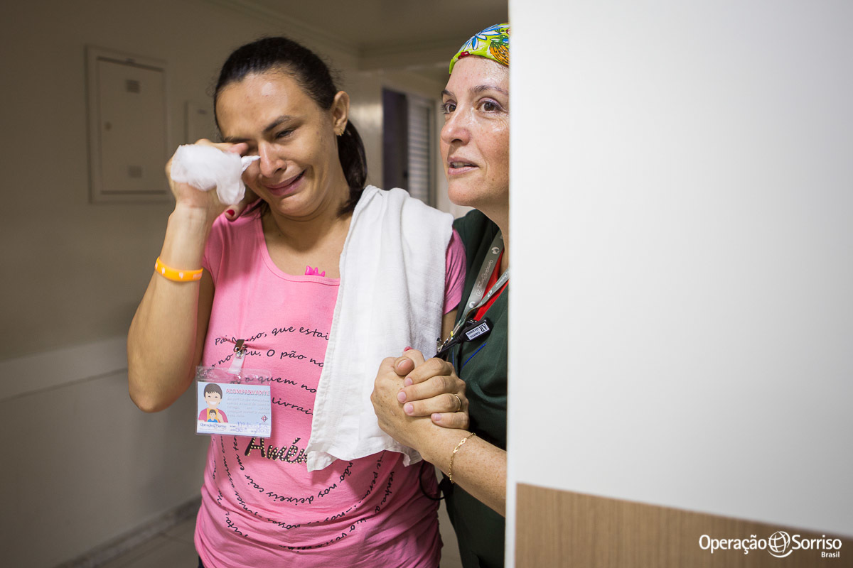 psicologa acalmando segurando a mão da mãe  da criança que entrou no centro cirurgico