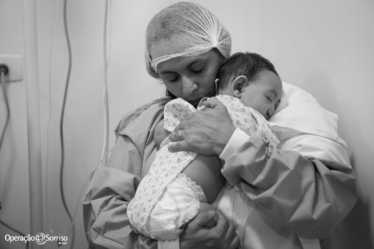 mãe abraçada com filha apos submeter a cirurgia de labio leporino