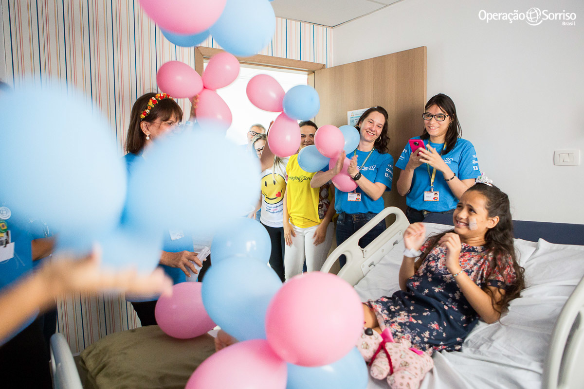 voluntarios da Operação Sorriso cantam parabéns para menina em seu quarto após cirurgia