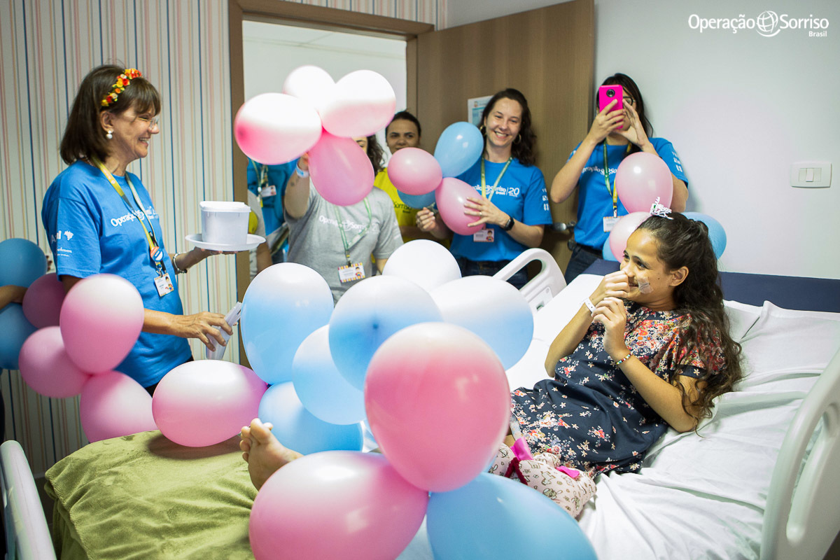 voluntarios da Operação Sorriso cantam parabéns para menina em seu quarto após cirurgia