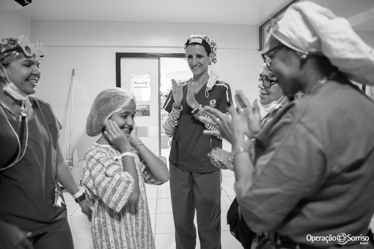 voluntarios da Operação Sorriso cantam parabéns para menina antes de entrar no centro cirurgico