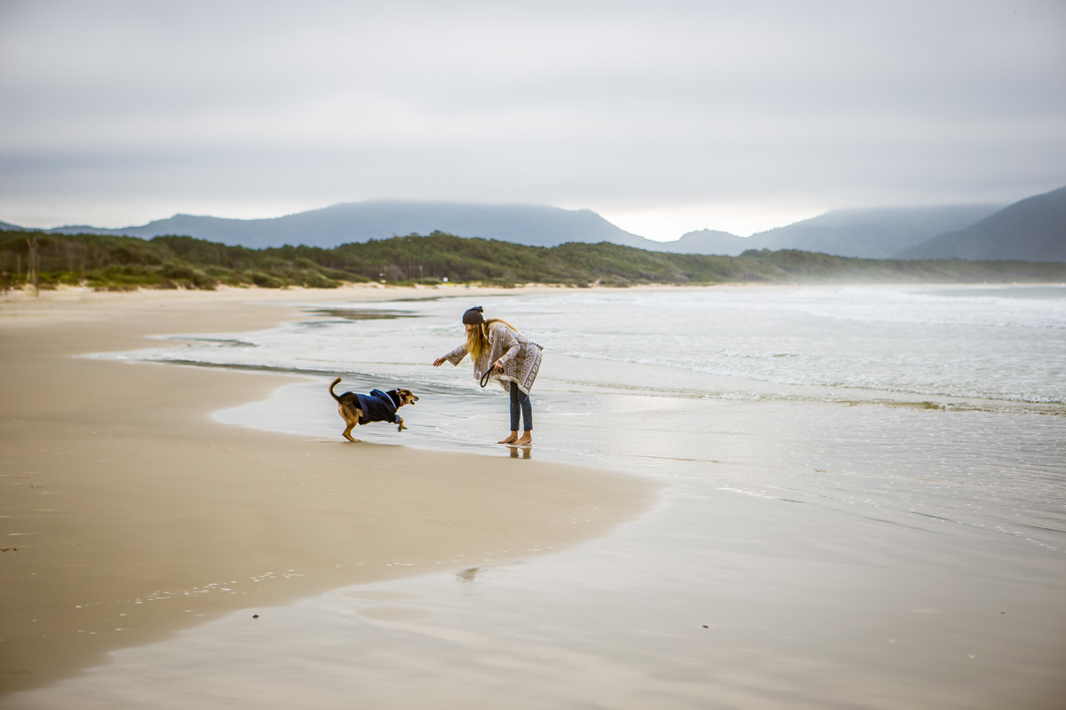 Cachorra brincando com mulher na praia