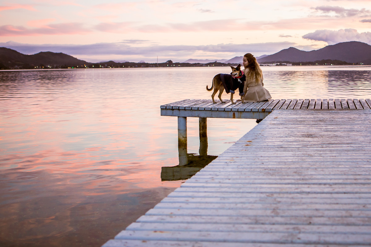 Cachorra e mulhers curtindo por do sol no trapiche