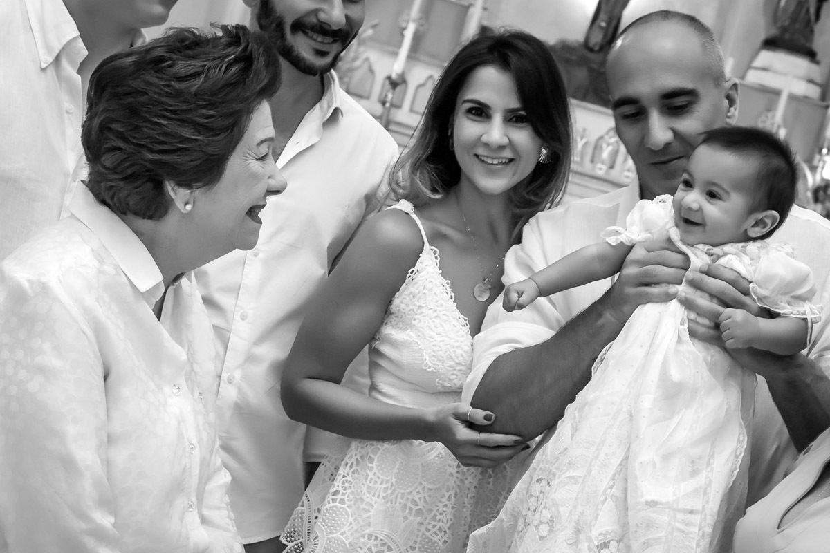 pai segurando bebe que sorri para a vó