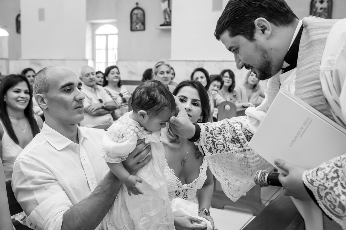 padre unge criança com óleo batismal