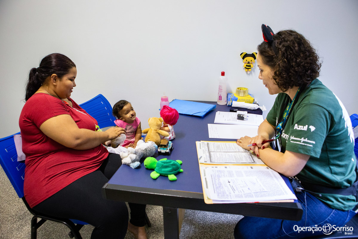 fonoaudiologa conversando com criança fissurada e sua mãe