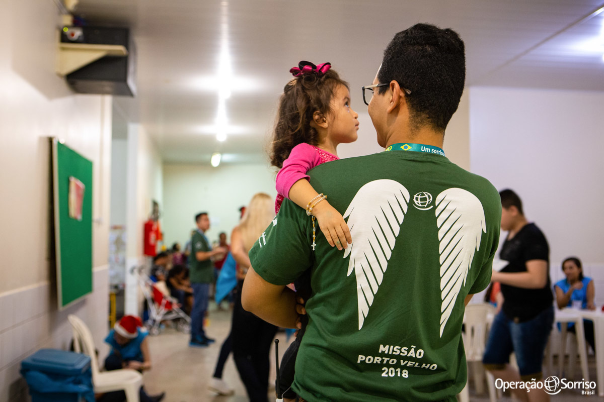 voluntario com criança no colo