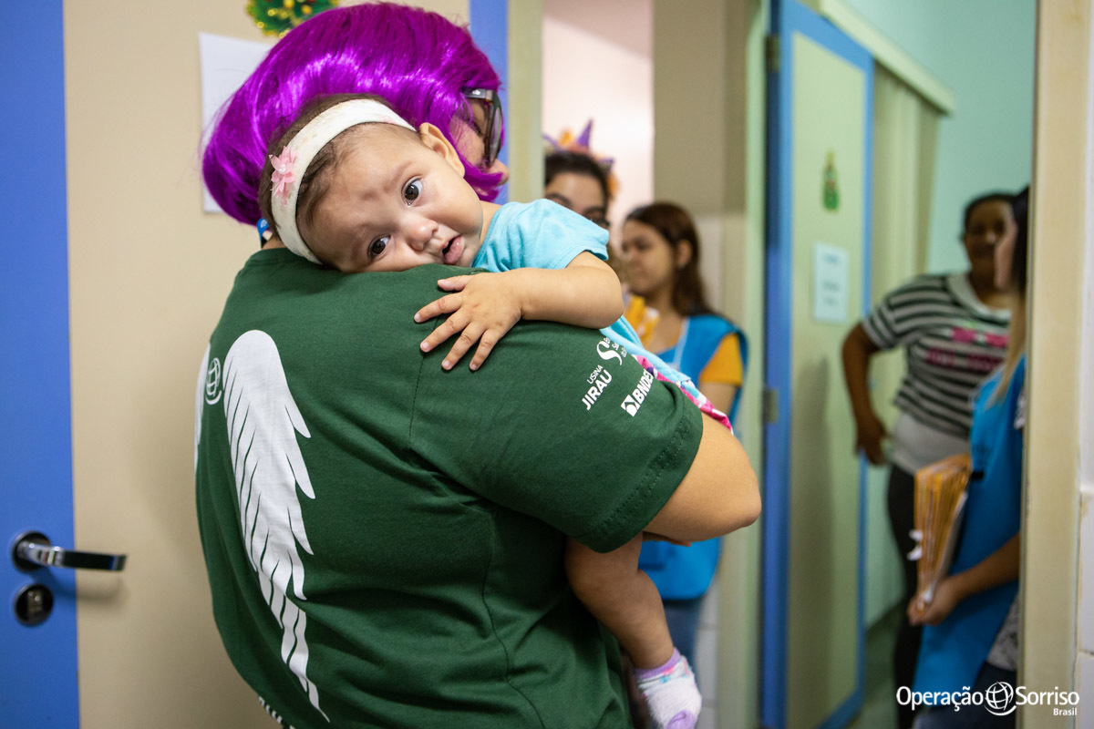 criança abraçada no colo de voluntaria