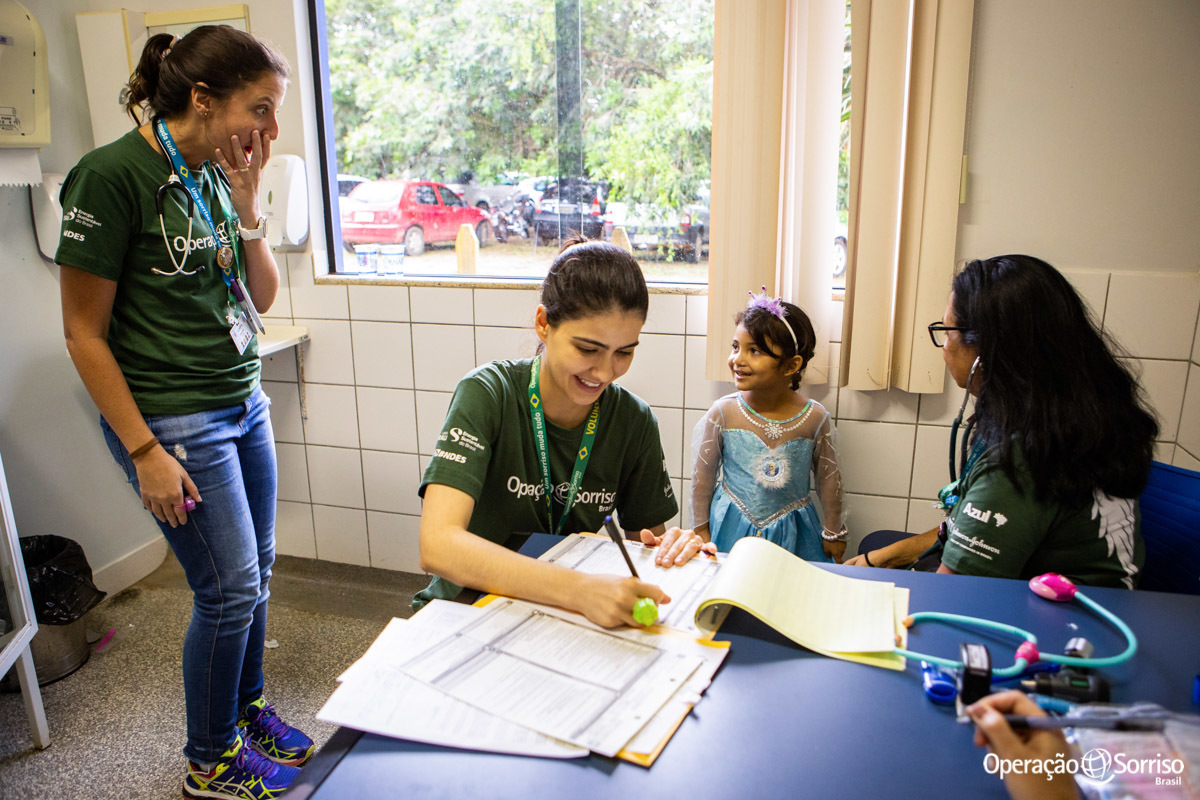 menina fantasiada de elsa dentro do consultorio e medicas rindo surpresas