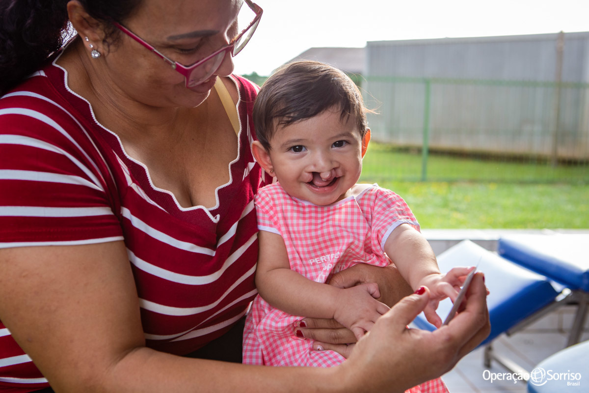 criança fissurada sorrindo enquanto se olha na foto