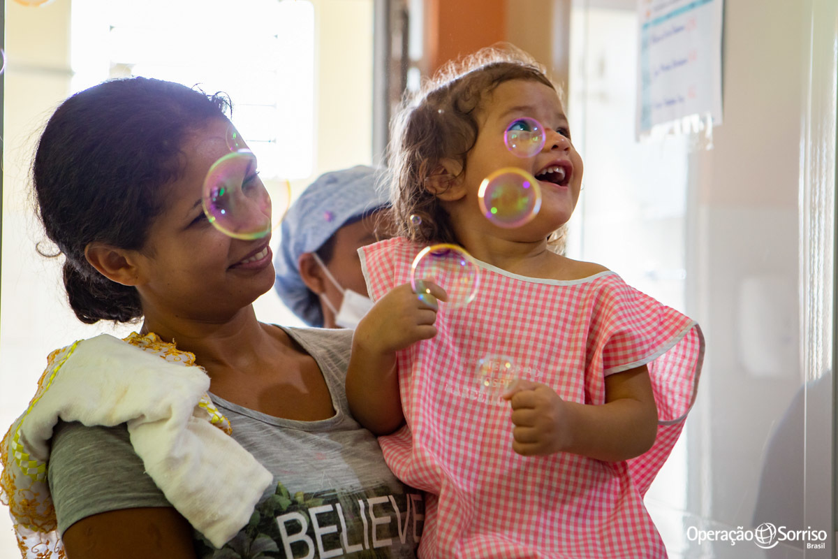 criança sorrindo com bolhas de sabão