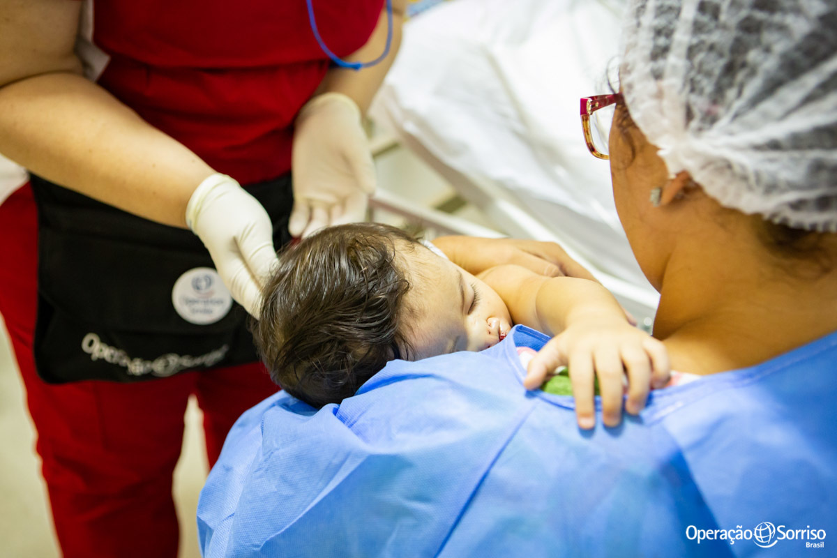 mãe com criança dormindo no seu colo