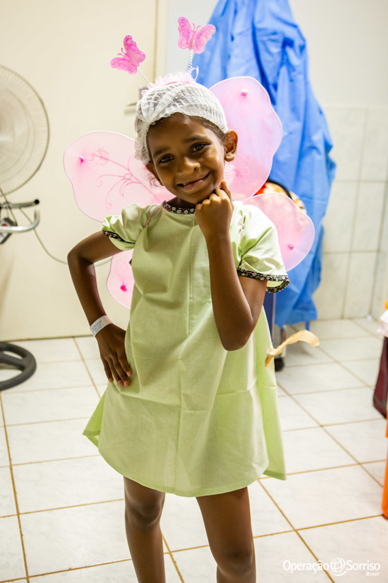 criança com pijama cirurgico e asas de borboleta